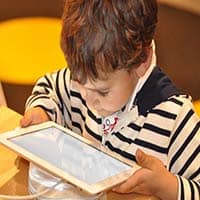 photo of a young boy viewing content on a tablet computer